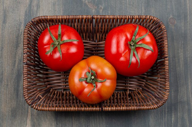 Fresh juicy tomatoes in a wicker basket 