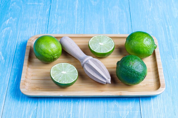 Fresh key limes with wooden citrus juicer