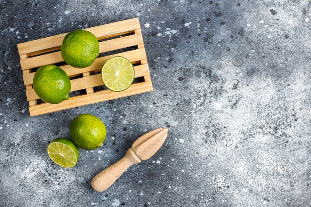 Fresh key limes with wooden citrus juicer