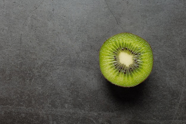 Fresh kiwi, cut into half, put on dark floor