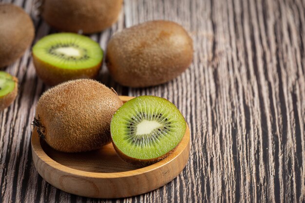 Fresh kiwi, cut into half, put on a wooden bowl