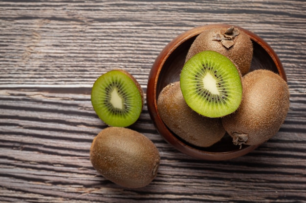 Free photo fresh kiwi, cut into half, put on a wooden bowl