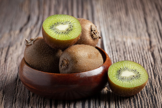 Fresh kiwi, cut into half, put on a wooden bowl