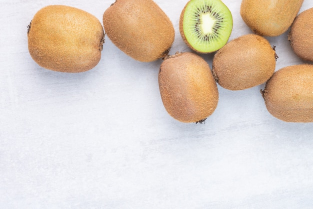 Fresh kiwi fruits, whole and sliced, on the marble.