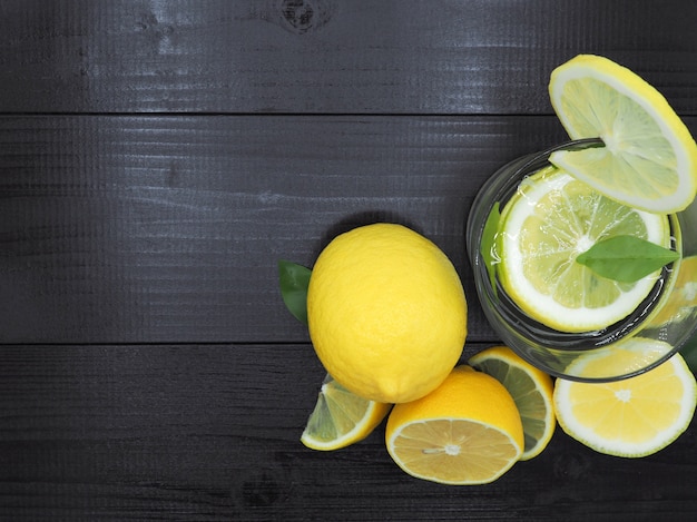 Свежий лимонный сок в небольшой миске и ломтик лимона на фоне темного дерева Premium Фотографии