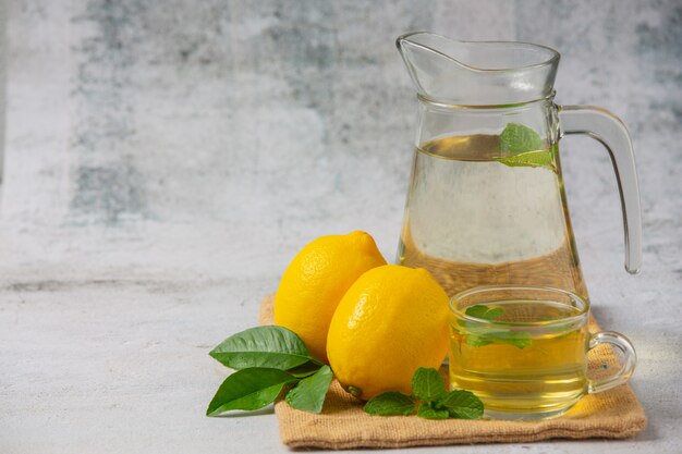 свежий лимон и лимонный сок в стеклянной банке