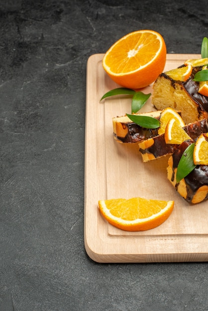 Fresh lemon slices and freshly baked chopped cake slices on dark table