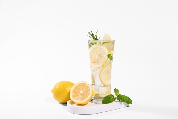 Free photo fresh lemon water in glass with lemon slices fruits isolated on white background