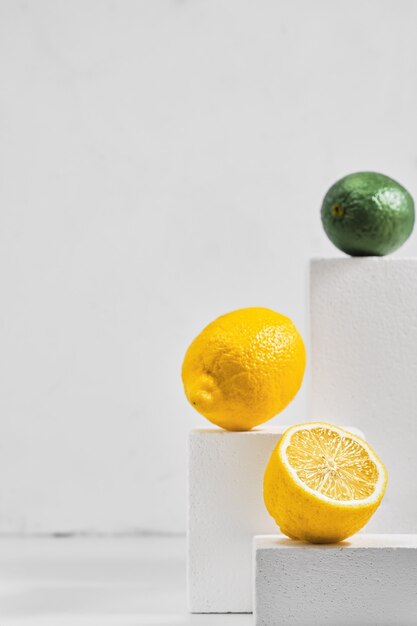 Fresh lemons and limes on gray table, minimalistic concept with citrus fruits