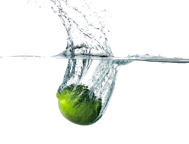 Fresh lime falling into water