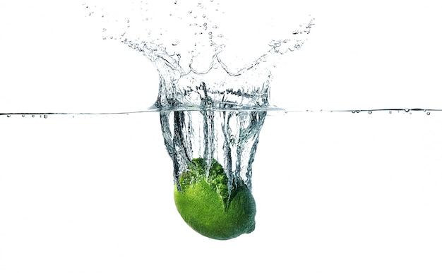 Fresh lime falling into water