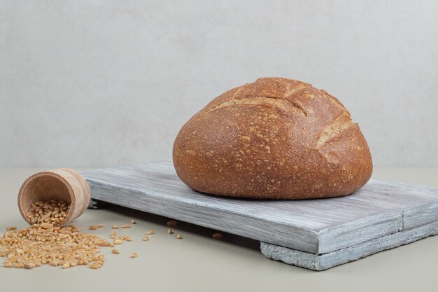 Fresh loaf of bread with oat grains on white background. High quality photo