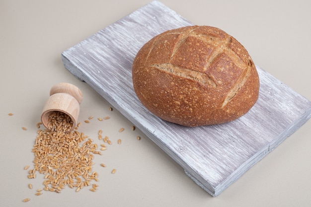 Fresh loaf of bread with oat grains on white background. High quality photo