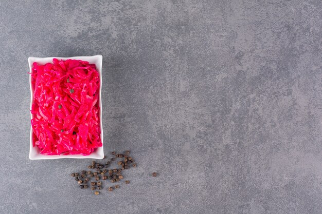 Fresh made portion of red Coleslaw placed on stone table.