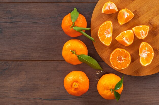 Fresh mandarins top view with copy space on wood cutting board