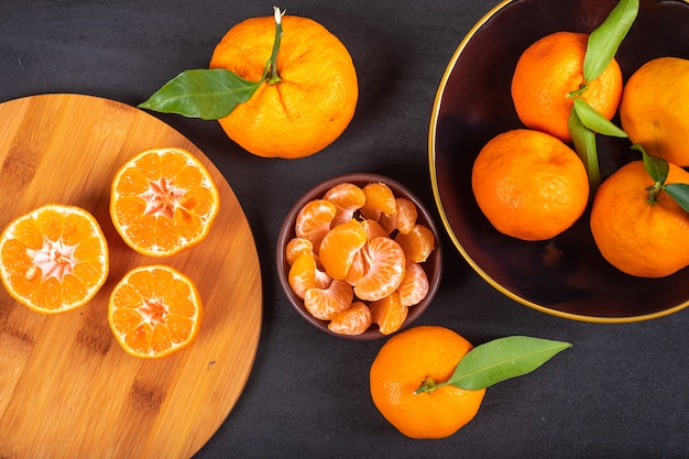 Fresh mandarins on wood cutting board and plate top view