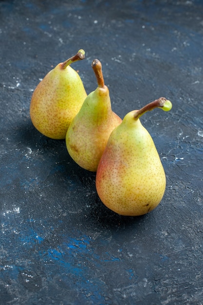 暗い机の上に並べられた新鮮なまろやかな梨全体の熟した甘い果物