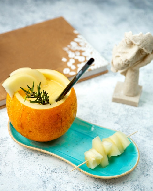 Fresh melon with a straw and sliced melon