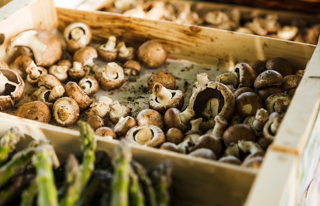 Funghi freschi in vassoio di legno al mercato degli agricoltori