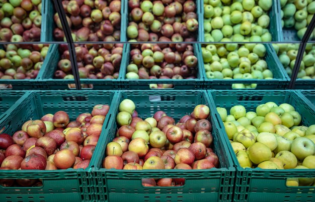 Fresh natural apples in crates on the supermarket counter.
