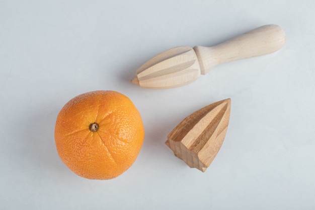 Свежие оранжевые фрукты с деревянными развертками, изолированными на белом фоне.