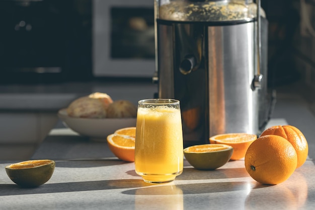 キッチンテーブルにグラスに新鮮なオレンジジュースを閉じる
