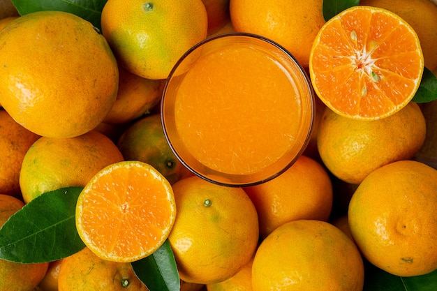 Fresh orange juice in the glass on dark wooden background