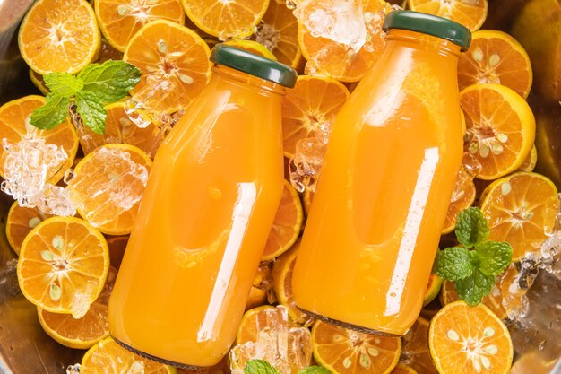 ガラスの瓶に入ったフレッシュ オレンジ ジュース、ミント、フレッシュ フルーツ。セレクティブ フォーカス。