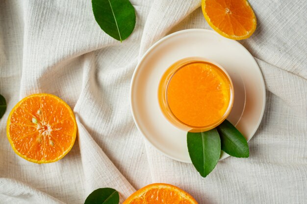 Fresh orange juice in the glass on marble background