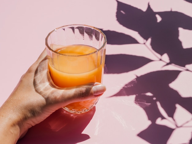 Free photo fresh orange juice in glass and shadows