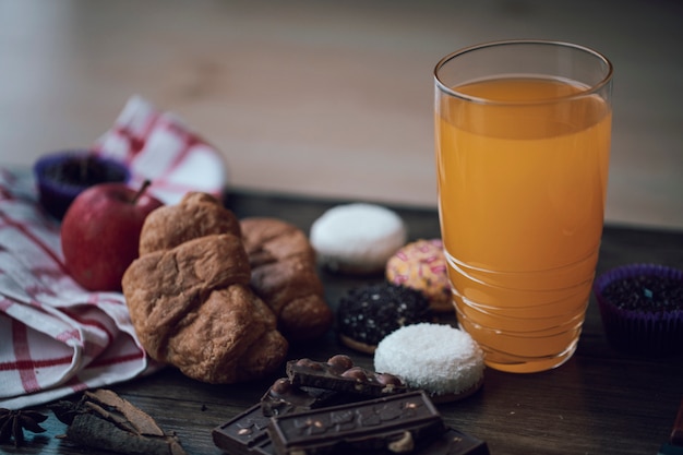 Fresh orange juice in the glass with variety of cookies