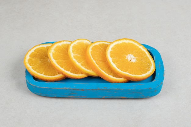 Fresh orange slices on blue plate