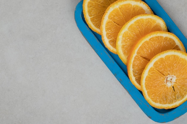 Fresh orange slices on blue plate