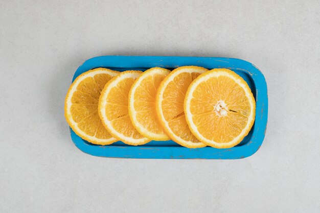 Fresh orange slices on blue plate