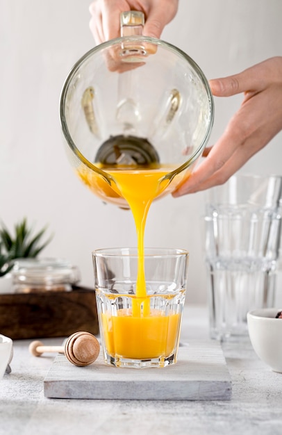 Fresh orange smoothie being poured in a glass