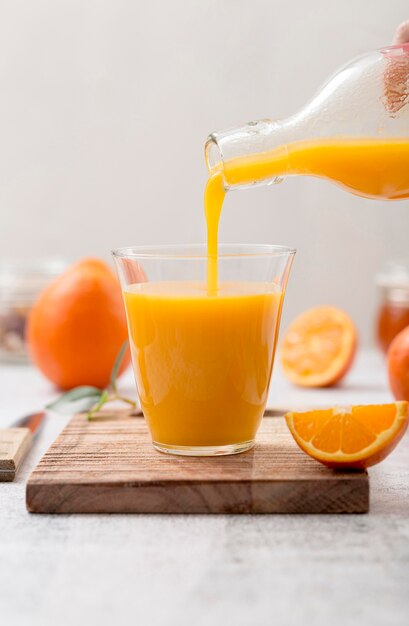 Свежий апельсиновый коктейль наливается в бокалы