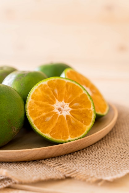 Free photo fresh orange on wood plate