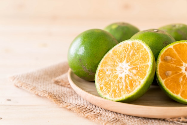 Free photo fresh orange on wood plate