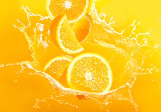 Fresh oranges falling in juice