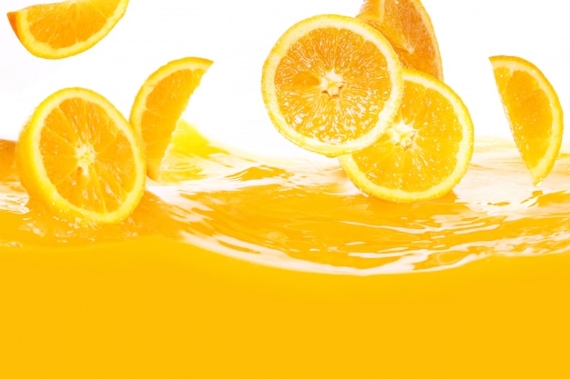 Fresh oranges falling in juice