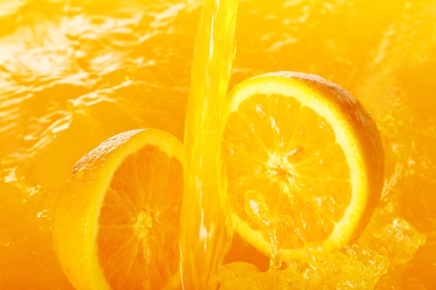 Fresh oranges falling in juice