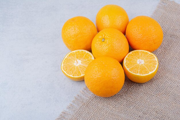 Fresh oranges lying on sackcloth on white background. High quality photo