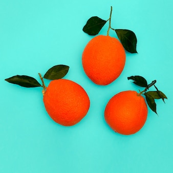 Свежие апельсины на синем фоне. минимальное плоское искусство