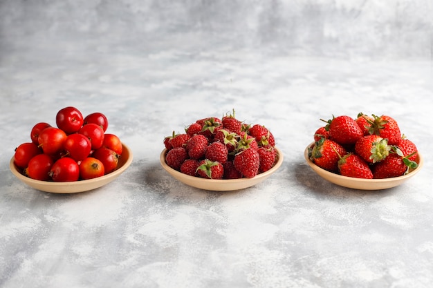 Fresh organic berries on grey concrete , top view,copyspace