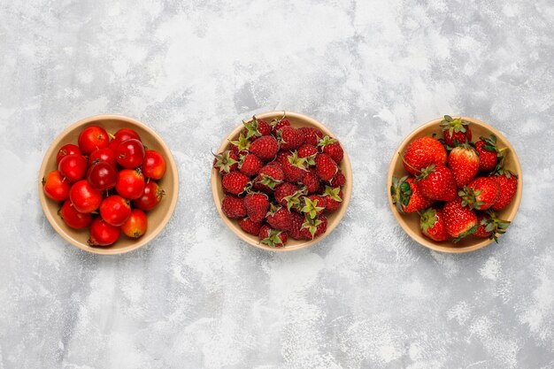 Fresh organic berries on grey concrete , top view,copyspace