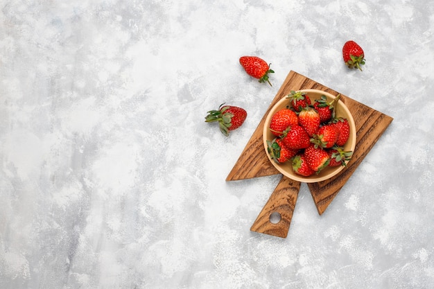 Free photo fresh organic berries on grey concrete ,top view,copyspace