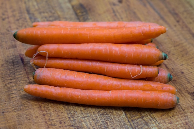 Free photo fresh organic carrots on a wooden background