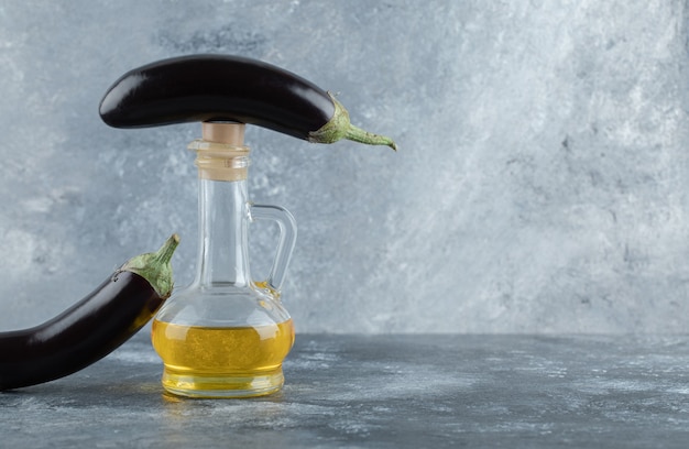 Fresh organic eggplants with bottle of oil.