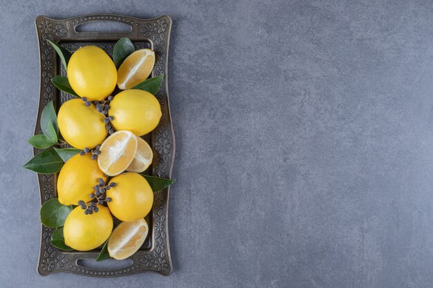 Free photo fresh organic lemon and slices on board.