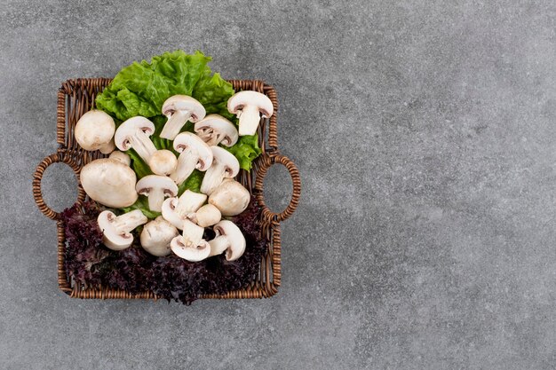 회색 표면 위에 바구니에 채소를 넣은 신선한 유기농 버섯